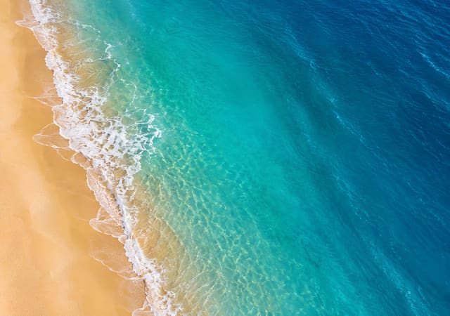 空拍浪花沙灘，iPhone Duo 內螢幕桌布，圖上沒有文字