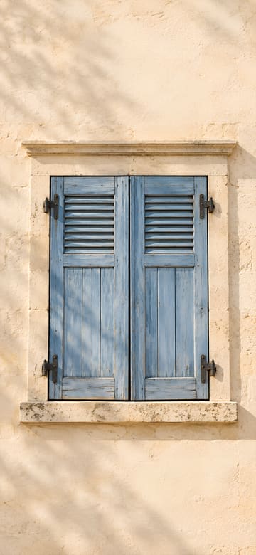 Volets bleus sur mur de pierre, fond d'écran de téléphone sans texte