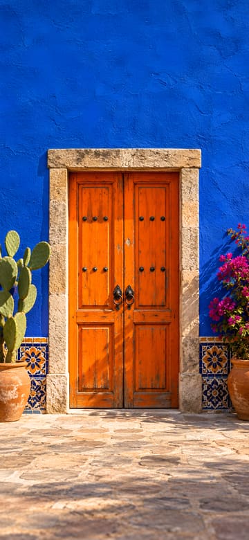 Puerta naranja y muro azul cobalto, fondo de pantalla para teléfono, sin texto